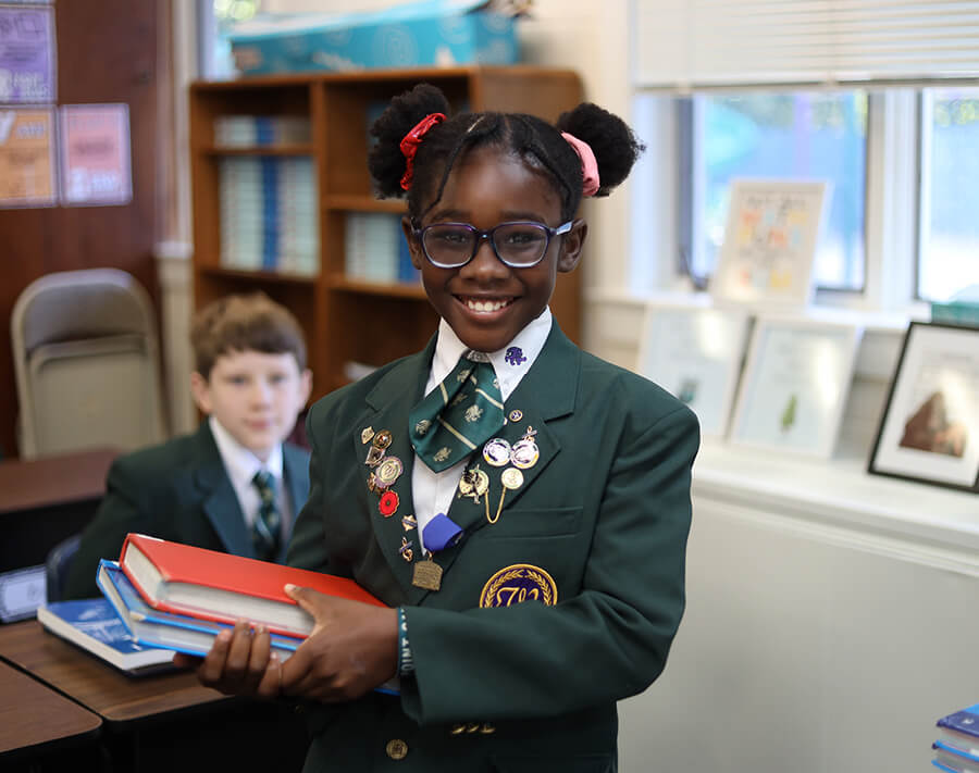 home-community Smiling preschool girl in uniform holding books