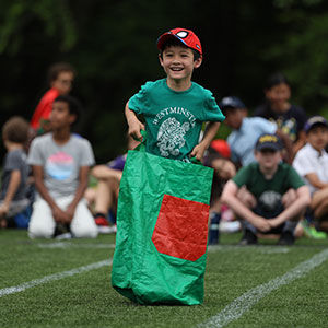 Child jumping in potato sack relay race