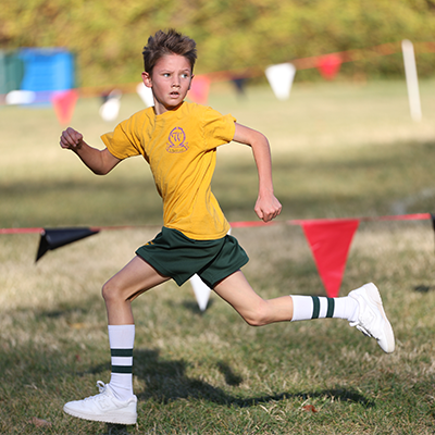 Boy running in cross country meet looking back