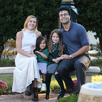 family-open-house Two parents and daughters sitting on bench family photo