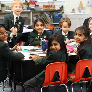 About-Mega students working together around a table