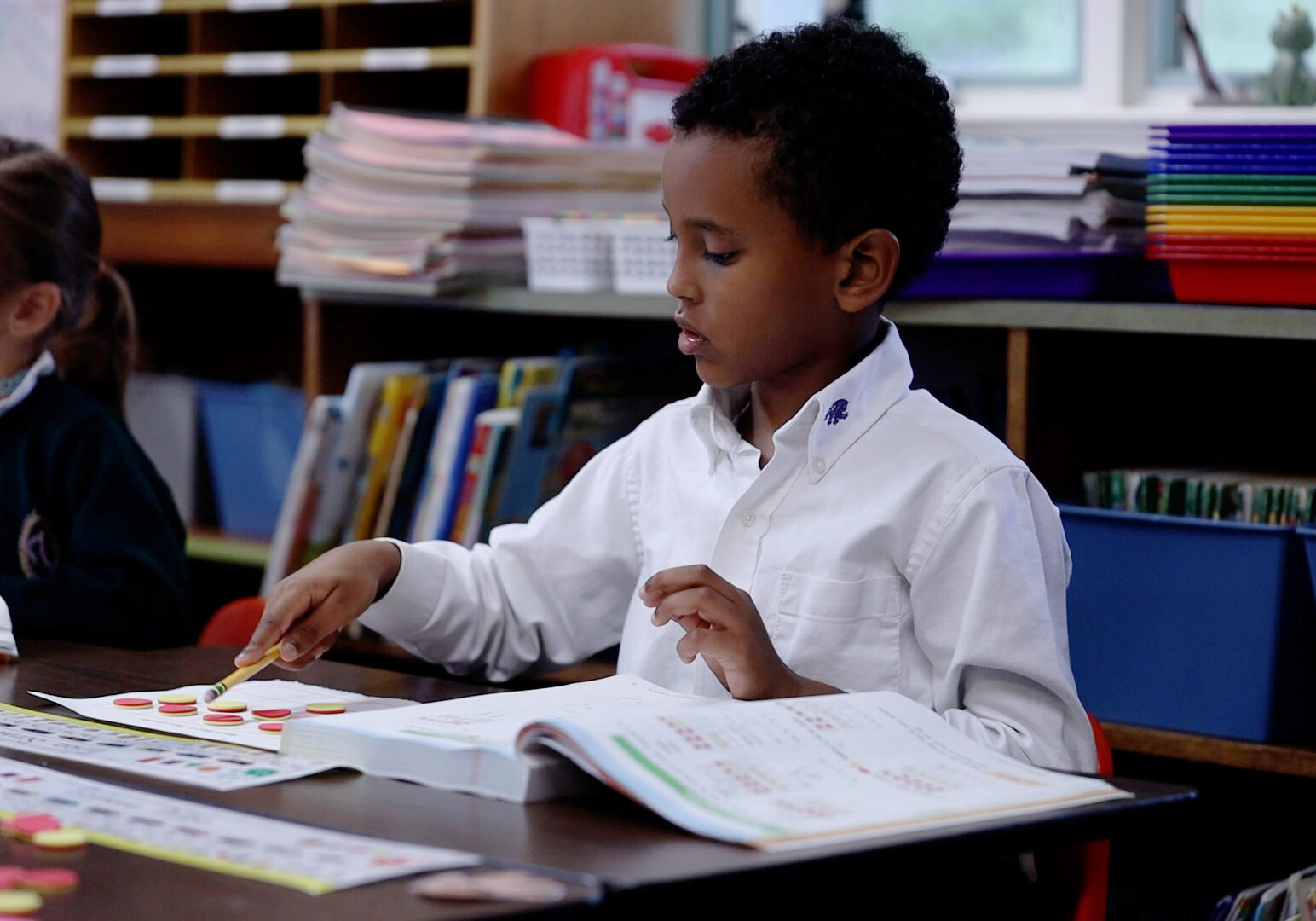 classroom kg Kindergarten student using counting tokens during a classroom activity